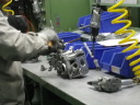 広くキレイな工場内。　熟練工の手により組まれていくエンジン。